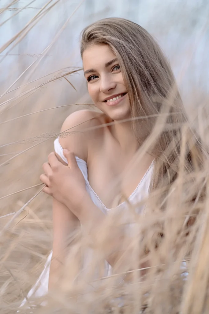zdjecie dziewczyny z dlugimi wlosami w zoltej trawie tomaszroman fotografia portretowa kobieca mragowo olsztyn mazury